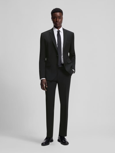 Männermodel trägt Slim Fit Anzugsakko aus Woll-Mix Modell 'ARTI' von HUGO in Schwarz mit Melange-Optik, Ganzkörperansicht von vorne.
