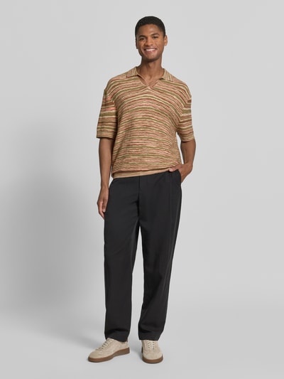 Männermodel trägt Relaxed Fit Poloshirt aus reiner Baumwolle Modell 'Muse' von SELECTED HOMME mit Optik: Allover-Muster, gestreift, Struktur, Johnny-Kragen, Kurzarm, gerippte Abschlüsse, Materialverarbeitung: Strick, in warmen Braun- und Grüntönen, weiche Textur, Ganzkörperansicht von vorne.