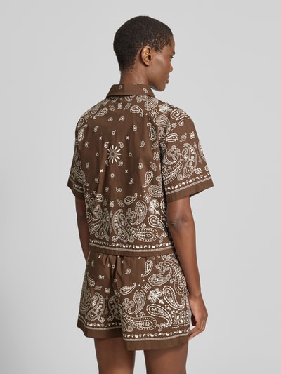 Vrouwenmodel draagt Regular Fit overhemdblouse met 1/2-mouwen model 'LUZ' van SUNCOO PARIS van puur katoen, ruglengte maat S 54 cm, mouwlengte 22 cm, kentkraag, bruin met witte paisley print, detailrijke textuur, achteraanzicht geheel lichaam.