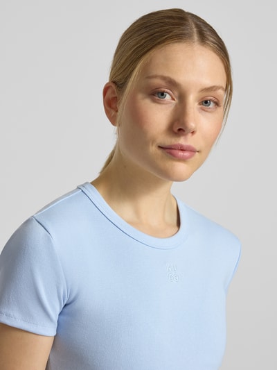 Frauenmodel trägt Slim Fit T-Shirt aus Baumwoll-Mix Modell 'DELANOR' von HUGO in Hellblau, schlicht, Logo-Stitching, Nahaufnahme Oberkörper.