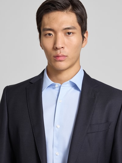 Männermodel trägt Slim Fit Businesshemd aus Baumwoll-Mix Modell 'HANK' von BOSS, Hellblau, Struktur, Kentkragen, Nahaufnahme Oberkörper.