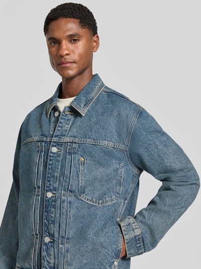 Männermodel trägt Regular Fit Jeansjacke aus Baumwoll-Lyocell-Mix Modell 'AASHTON' von ARMEDANGELS, blaue Denim-Optik, Nahaufnahme Oberkörper, Herren Jeansjacke.