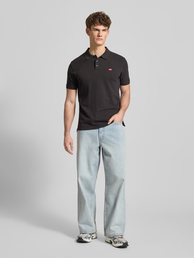 Männermodel trägt Poloshirt mit Label-Detail von Levi's®, Reine Baumwolle, Regular Fit, Polokragen, Ganzkörperansicht von vorne.