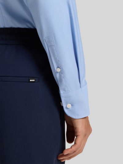 Männermodel trägt Slim Fit Businesshemd aus Stretch-Twill Modell 'P-HANK-KENT-C1-222' von BOSS in Hellblau, Nahaufnahme Unterarm.