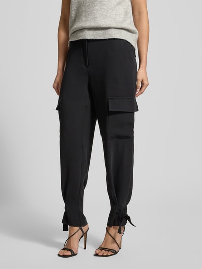 Kobiece modelka nosi Cargohose mit Gesäßtaschen od comma, proste nogawki, czarne, kieszenie z patką, widok całej sylwetki z przodu.