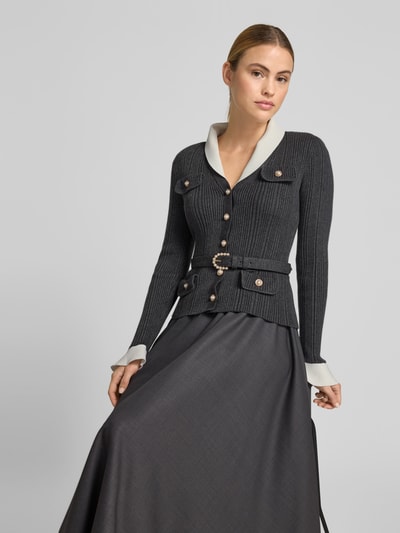 Frauenmodel trägt Maxikleid mit Woll-Anteil von Self-Portrait in dunkelgrauer Strick-Optik, durchgängige Knopfleiste, taillierte Passform, langärmelig, Material-Mix, Gesamtlänge bei Größe 36: 136 cm, Brustweite: 39 cm, Taillenweite: 29 cm. Nahaufnahme Oberkörper.