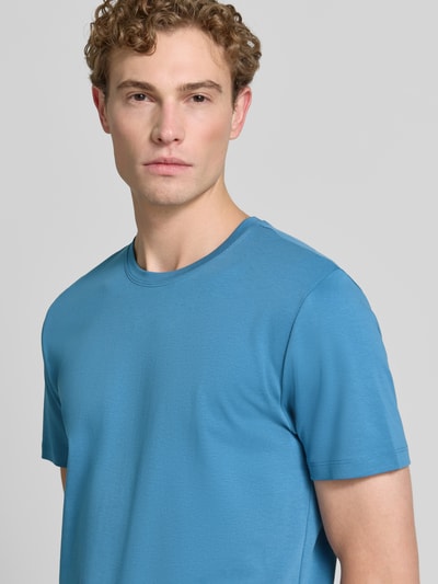 Męskimodel nosi T-Shirt aus Baumwolle mit Rundhalsausschnitt von Christian Berg Men w kolorze niebieskim, krój regular fit, okrągły dekolt, długość tyłu w rozmiarze M: 35 cm, zbliżenie górnej części ciała.