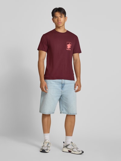 Männermodel trägt T-Shirt mit Motiv-Print und Rundhalsausschnitt von Replay, reine Baumwolle, Regular Fit, rot, Ganzkörperansicht von vorne.