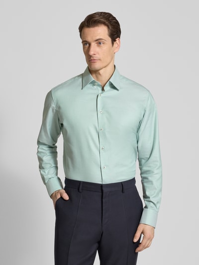 Männermodel trägt Regular Fit Business-Hemd mit Kentkragen von ETERNA in Mint, Reine Baumwolle, durchgehende Knopfleiste, Ganzkörperansicht von vorne.