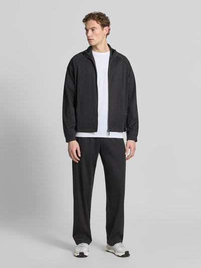 Männermodel trägt Sweatjacke mit Stehkragen und Zweiwege-Reißverschluss von Emporio Armani aus Lyocell-Mix mit Viskose-Anteil, Regular-Fit, schwarz, Eingrifftaschen, Rückenlänge 68 cm, Ärmellänge 84 cm, Ganzkörperansicht von vorne.