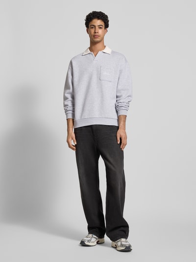 Mannelijk model draagt 'Sweatshirt met contrastkraag en borstzak met logo-borduring' van REVIEW, Materiaalmix met katoen, regular fit, contrastkraag, borstzak met geborduurd logo, ruglengte maat M 71 cm, mouwlengte maat M 63 cm, lichtgrijs met beige kraag, zachte stof, casual look. Ganzkörperansicht van voren.