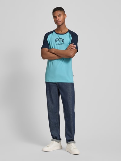 Mężczyzna nosi Regular Fit T-Shirt aus reiner Baumwolle von s.Oliver RED LABEL, kolor two tone, nadruk statement, okrągły dekolt, krótki rękaw, bawełna, widok całej sylwetki z przodu.