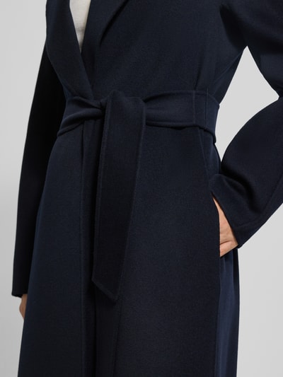 Frauenmodel trägt Relaxed Fit Wollmantel mit Seiden-und Kaschmir-Anteil Modell 'MSTCLES' von Max Mara Studio, Optik: Unifarben, Passform: Relaxed-Fit, Reverskragen, Taillengürtel, Gehschlitz, Langarm, seitliche Eingrifftaschen, Material: Schurwoll-Mix, Nahaufnahme Oberkörper.