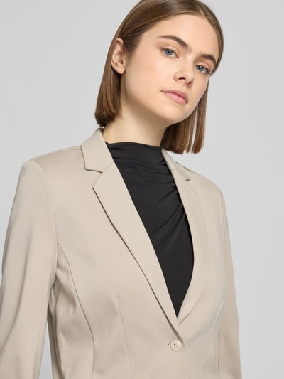 Frauenmodel trägt taillierten Blazer aus Viskose-Mix Modell 'POPTRASH' von Only in Beige, Reverskragen, Nahaufnahme Oberkörper.