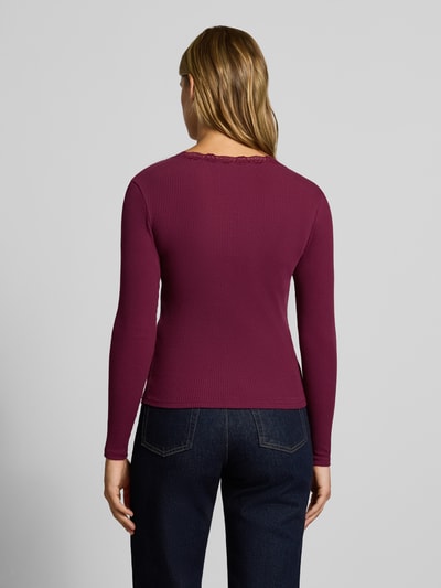 Frauenmodel trägt Slim Fit Langarmshirt aus Baumwoll-Mix Modell 'SARA SHARAI' von ONLY in Dunkelrot, strukturierte Oberfläche, Ganzkörperansicht Rückansicht, Damen Langarmshirt von ONLY.