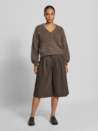 Frauenmodel trägt Strickjacke aus Woll-Mohair-Mix Modell 'debbie' von Gestuz in meliertem Braun mit V-Ausschnitt und gerippten Ärmelabschlüssen, lockere Passform, Ganzkörperansicht von vorne.