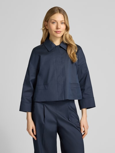 Modelka prezentuje Relaxed Fit Blazer mit Umlegekragen od Windsor, elastyczna mieszanka materiałów, kieszenie z wypustkami, kolor granatowy, długość tyłu w rozmiarze 36: 51 cm, szerokość w rozmiarze 36: 42 cm, długość rękawów w rozmiarze 36: 37 cm, widok całej sylwetki z przodu