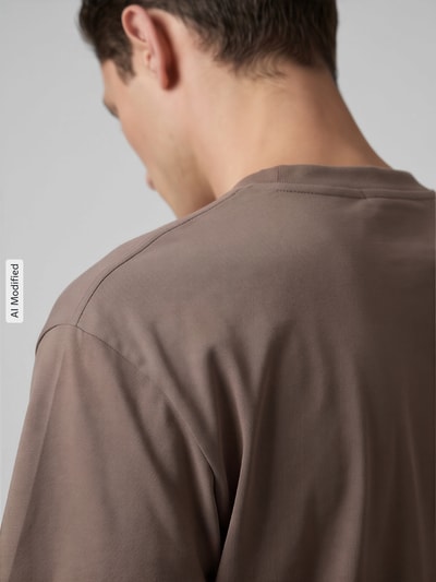 Männermodel trägt Relaxed Fit T-Shirt aus reiner Baumwolle von Marc O'Polo DENIM in Braun, glatte Oberfläche, Ganzkörperansicht Rückansicht, KI-modifiziertes Bild.