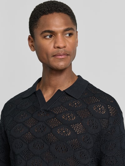 Männermodel trägt Slim Fit Poloshirt in Strick-Optik Modell 'Angvig' von Casual Friday, Reine Baumwolle, semitransparent, Nahaufnahme Oberkörper.
