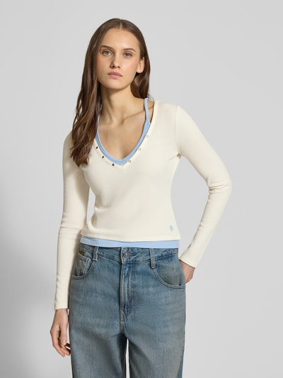 Frauenmodel trägt Slim Fit Longsleeve mit Strukturmuster von Guess Jeans, elastischer Material-Mix, Layered-Look, Druckknopfbesatz, Rückenlänge Größe S 47 cm, cremefarben und blau, Ganzkörperansicht von vorne.