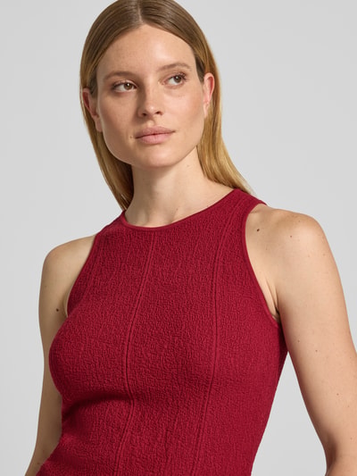Frauenmodel trägt Relaxed Fit Top aus Viskose-Mix Modell 'Charlitta' von MSCH Copenhagen in Dunkelrot mit Strukturmuster, Nahaufnahme Oberkörper, Rückenlänge bei Größe XS/S 54 cm.
