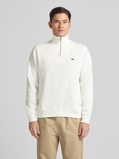 Männermodel trägt Regular Fit Troyer aus reiner Baumwolle von Lacoste, Optik: Unifarben, Strick, Logo-Patch, Ganzkörperansicht von vorne.