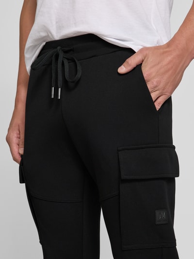 Männermodel trägt Regular Fit Sweatpants mit Cargotaschen von Antony Morato in Schwarz, Baumwoll-Mix, Nahaufnahme Oberschenkel.