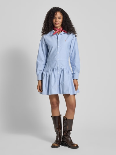 Frauenmodel trägt Tailliertes Blusenkleid aus reiner Baumwolle von Polo Ralph Lauren in Hellblau mit Polokragen, Logo-Detail und Knopfleiste, Oxford-Textur, uni, Mini-Länge, Ganzkörperansicht von vorne.