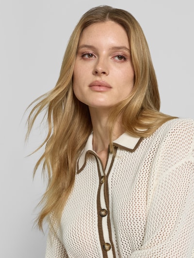 Frauenmodel trägt Strickshirt mit Polokragen und Knopfleiste von Style Icon Collection, Reine Baumwolle, Grobstrick, Nahaufnahme Oberkörper.