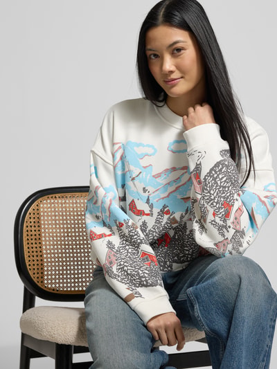 Frauenmodel trägt Oversized Sweatshirt mit gerippten Abschlüssen von Jake*s Casual, weiß mit buntem Landschaftsprint, Baumwoll-Mix, Nahaufnahme Oberkörper.