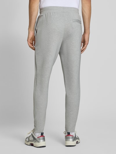 Männermodel trägt graue Regular Fit Sweatpants mit Lyocell-Anteil von PUMA PERFORMANCE, elastischer Bund, Ganzkörperansicht Rückansicht.