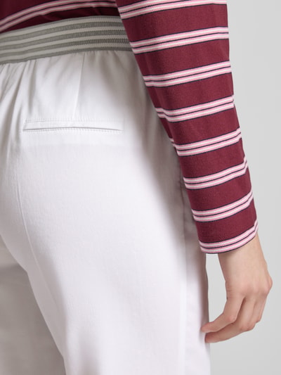 Frauenmodel trägt Wide Fit Stoffhose in 7/8-Länge Modell 'Sue' von TONI aus Baumwoll-Mix mit Bügelfalten und Eingrifftaschen, Detailaufnahme.