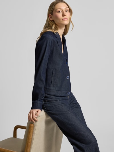 Vrouwenmodel draagt Regular Fit Kurzblazer aus Denim van s.Oliver BLACK LABEL in donkere denimlook, mix van viscose en katoen, reverskraag, eenrijige knoopsluiting, steekzakken, lange mouw met manchet, Ganzkörperansicht van voren.