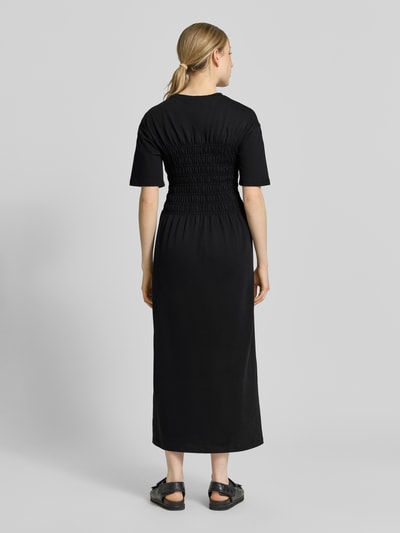 Frauenmodel trägt Midikleid mit Smok-Details von Jake*s Casual in Schwarz, reine Baumwolle, tailliert, Ganzkörperansicht Rückansicht.