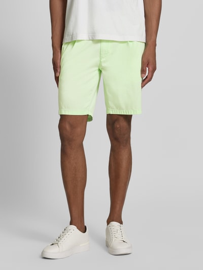 Männermodel trägt Relaxed Fit Bermuda aus Baumwoll-Mix Modell 'TINO' von Brax, Optik: Unifarben, Passform: Relaxed-Fit, Gürtelschlaufen, Knopf und verdeckter Reißverschluss, seitliche Eingrifftaschen, Material: Baumwoll-Mix, helle Grünfarbe, glatte Textur, Ganzkörperansicht von vorne.