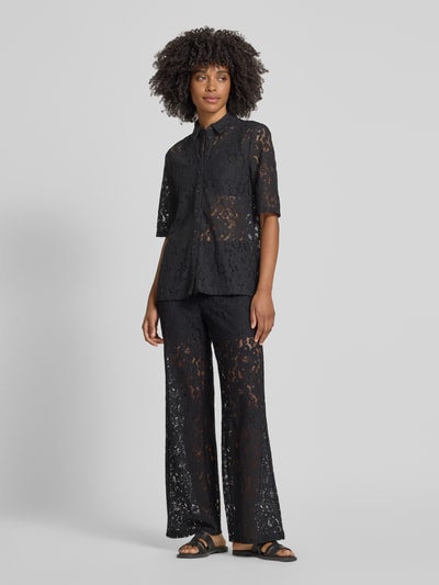 Frauenmodel trägt Regular Fit Bluse aus Baumwoll-Mix Modell 'HONEY' von Vero Moda, Optik: Unifarben, Passform: Regular-Fit, Kragenform: Hemdkragen, Optik:Allover-Muster, Ausschnitt: V-Ausschnitt, einreihige Knopfleiste, Ärmelform: Langarm, Material: Baumwoll-Mix, schwarze Spitze mit floraler Textur, Ganzkörperansicht von vorne.