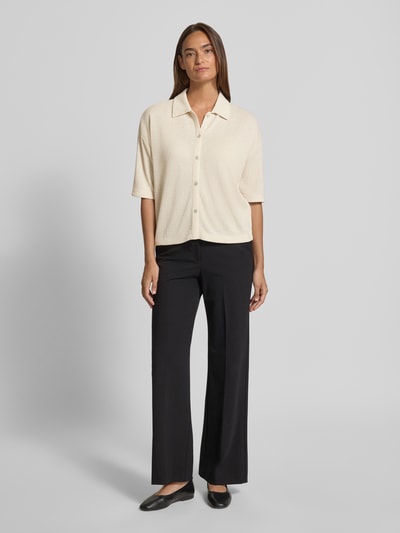 Frauenmodel trägt Strickshirt aus Viskose-Mix mit Polokragen Modell 'Sitrica' von OPUS, Relaxed-Fit, helle Farbe, Knopfleiste, Rückenlänge bei Größe 36: 54 cm, Ganzkörperansicht von vorne.