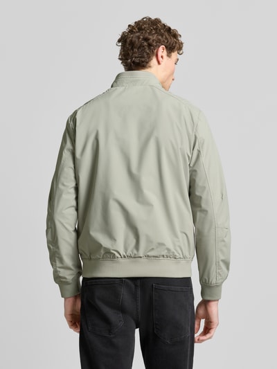 Männermodel trägt Regular Fit Jacke mit Stehkragen von Lerros in hellem Grün mit elastischen Abschlüssen, Reißverschlüssen, Rückenansicht.