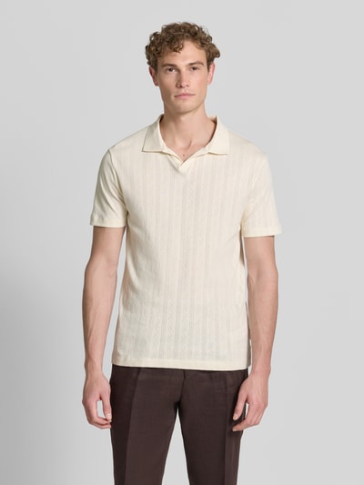 Męski model nosi Regular Fit Poloshirt in Jaquard-Strick von Lindbergh z bawełny o wzorze żakardowym, kołnierzyk polo, dekolt w serek, detal z logo, długość tyłu w rozmiarze M: 73 cm, widok całej sylwetki z przodu