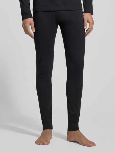 Männermodel trägt Stoffhose mit elastischem Bund von Schiesser, Baumwoll-Elasthan-Mix, körpernaher Schnitt, schwarze Farbe, Nahaufnahme Unterkörper.