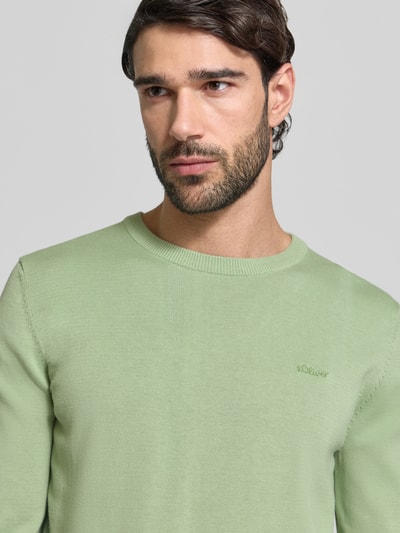 Mężczyznamodel nosi Regular Fit Pullover aus reiner Baumwolle od s.Oliver RED LABEL, melanżowa jasna zieleń, krój regular fit, okrągły dekolt, długi rękaw, dzianina, detal z logo, bawełna, widok z przodu, zbliżenie na górną część ciała.