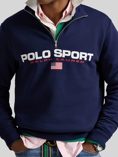 Männermodel trägt Relaxed Fit Troyer aus Baumwoll-Mix von Polo Ralph Lauren in Dunkelblau mit Label Print, Nahaufnahme Oberkörper.
