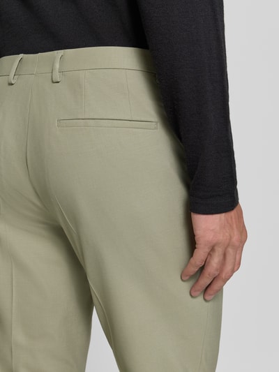 Männermodel trägt Regular Fit Anzughose mit Woll-Anteil Modell 'Hesten' von HUGO, efekt: jednolity kolor, szlufki na pasek, kanty, materiał z dodatkiem wełny, kieszeń z tyłu, Ganzkörperansicht Rückansicht