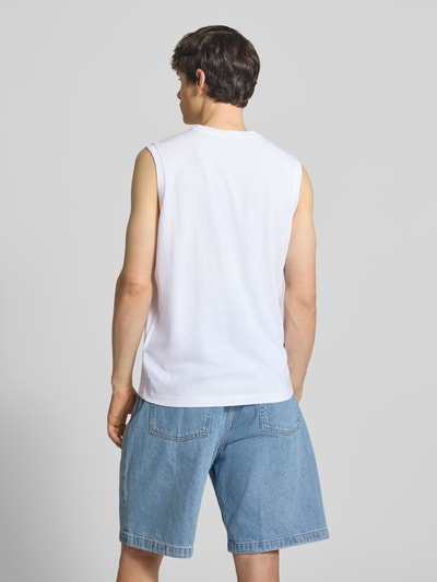 Männermodel trägt Top mit Logo und Rundhalsausschnitt von CHAMPION aus Baumwoll-Mix, Regular-Fit, weiße Farbe, Rückenlänge 69 cm, Ganzkörperansicht Rückansicht.