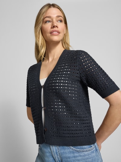 Frauenmodel trägt Regular Fit Cardigan aus Viskose-Mix Modell 'Dostal' von OPUS in Dunkelblau, Strick-Optik, kurzärmelig, V-Ausschnitt, semitransparent, Knopfleiste, Ganzkörperansicht von vorne.