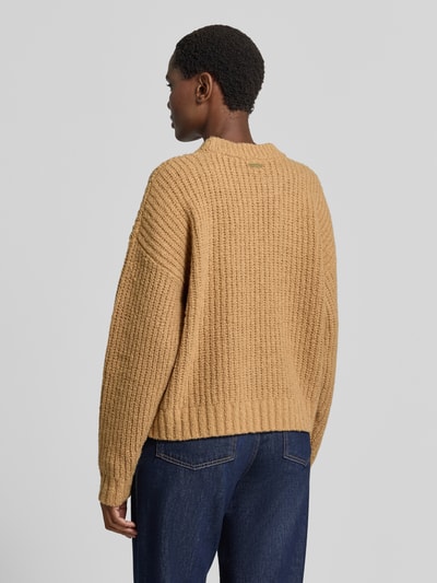 Vrouwenmodel draagt Oversized wollen trui uit wolmix van MICHAEL Michael Kors met ronde hals, structuurpatroon, ribboorden, ruglengte maat S 54 cm, mouwlengte maat S 50 cm, camel, rechte vormen, zachte textuur, volledige lichaamsopname achteraan.