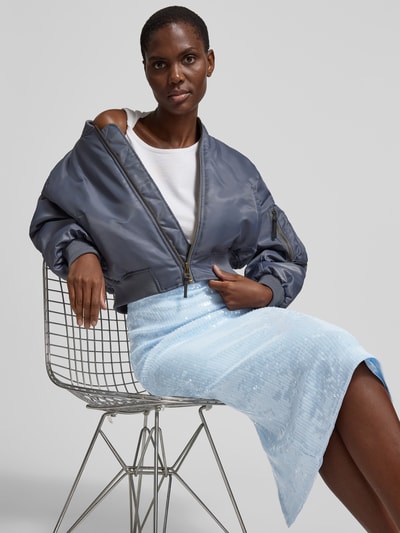 Frauenmodel trägt Midirock mit Allover-Pailettenbesatz von ROTATE in Hellblau aus Elastischer-Material-Mix, Slim-Fit, Nahaufnahme Oberkörper.