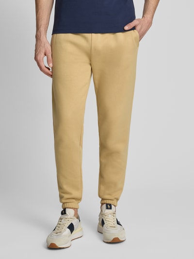 Männermodel trägt Sweatpants mit elastischem Bund von GAP, bawełniany miks, krój regular fit, kieszeń z tyłu, długość nogawki wewnętrznej w rozmiarze M 74 cm, całkowity widok z przodu.