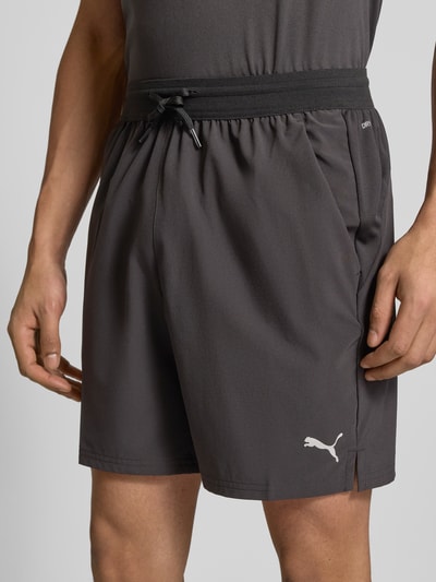 Männermodel trägt Shorts mit elastischem Bund und Logo von PUMA PERFORMANCE, Material-Mix mit Stretch-Anteil, Regular-Fit, Nahaufnahme Oberkörper.