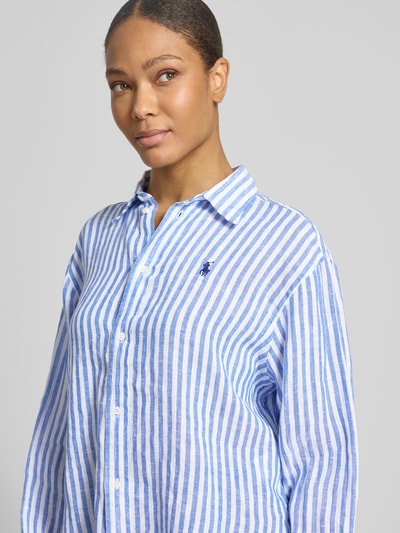 Frauenmodel trägt Boxy Fit Leinenbluse mit Allover-Muster von Polo Ralph Lauren in Gestreift Optik, Hemdblusenkragen, Logo-Stitching, Material: reines Leinen, Nahaufnahme Oberkörper.